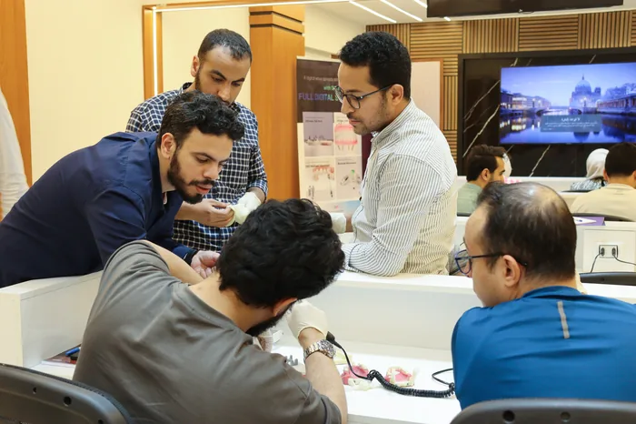 Participants gathered around a workbench watching a demonstration
