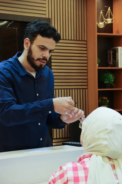 An instructor handing a component to a participant across a bench