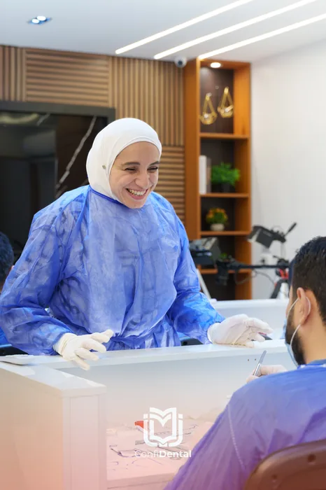 An instructor in surgical gown working with a participant at a clinical bench